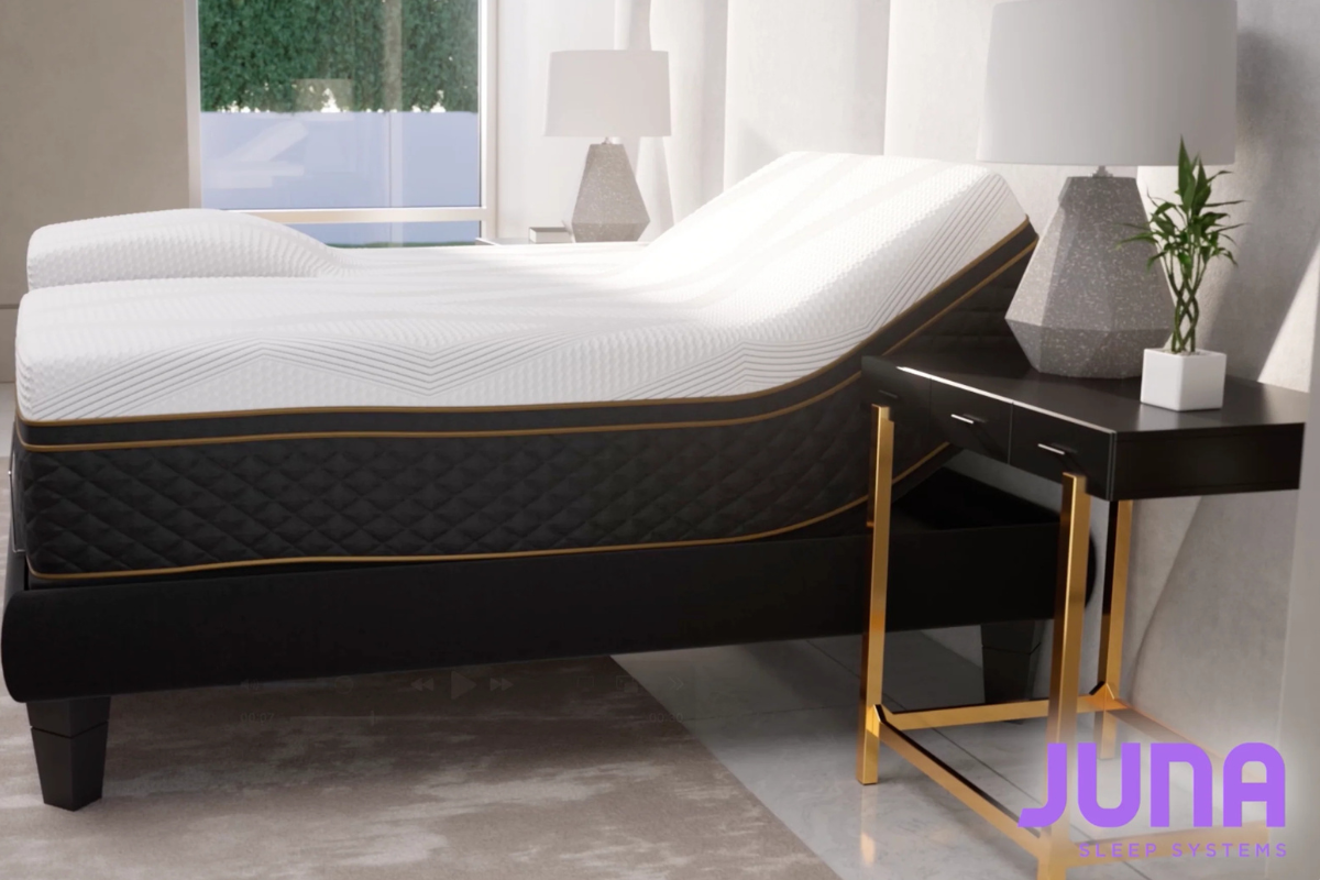 Juna Sleep mattress showcasing ergonomic design for spinal alignment, paired with modern bedside table and lamp, emphasizing sleep quality and comfort.