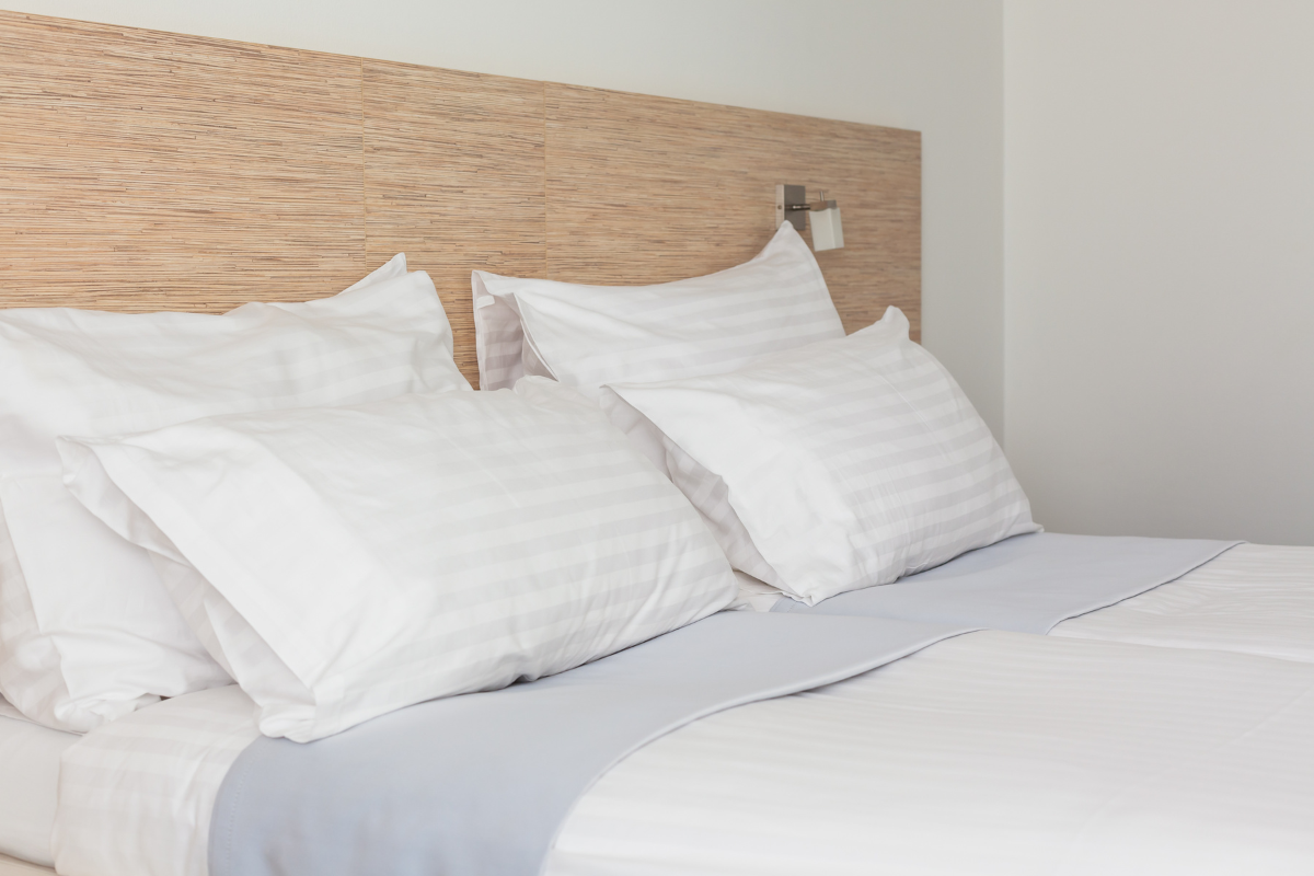 Adjustable bed with multiple white pillows and a light blue blanket, emphasizing comfort and support for a personalized sleep experience.