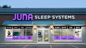 Juna Sleep Systems storefront in Rapid City, South Dakota, featuring prominent signage, promotional window displays, and a welcoming entrance for customers seeking sleep products.